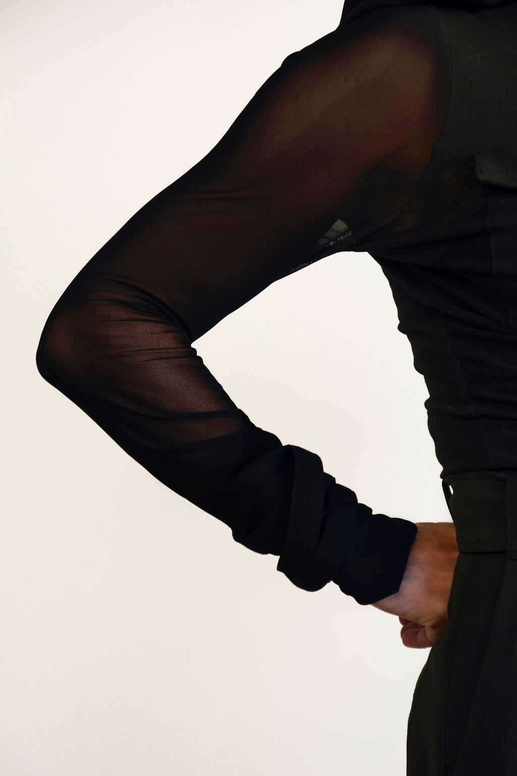 Black sheer long-sleeve top worn by a person on a plain background